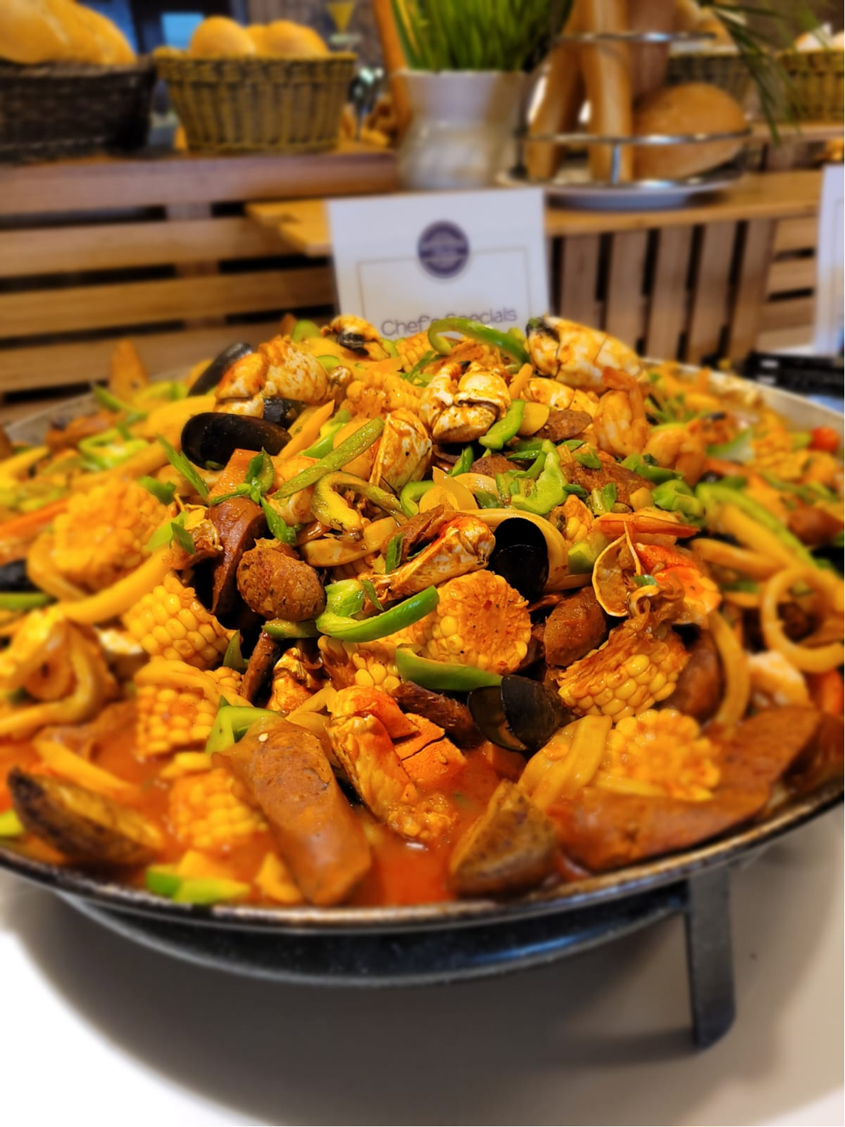 Large seafood paella with corn, sausage, shrimp, mussels, and peppers.