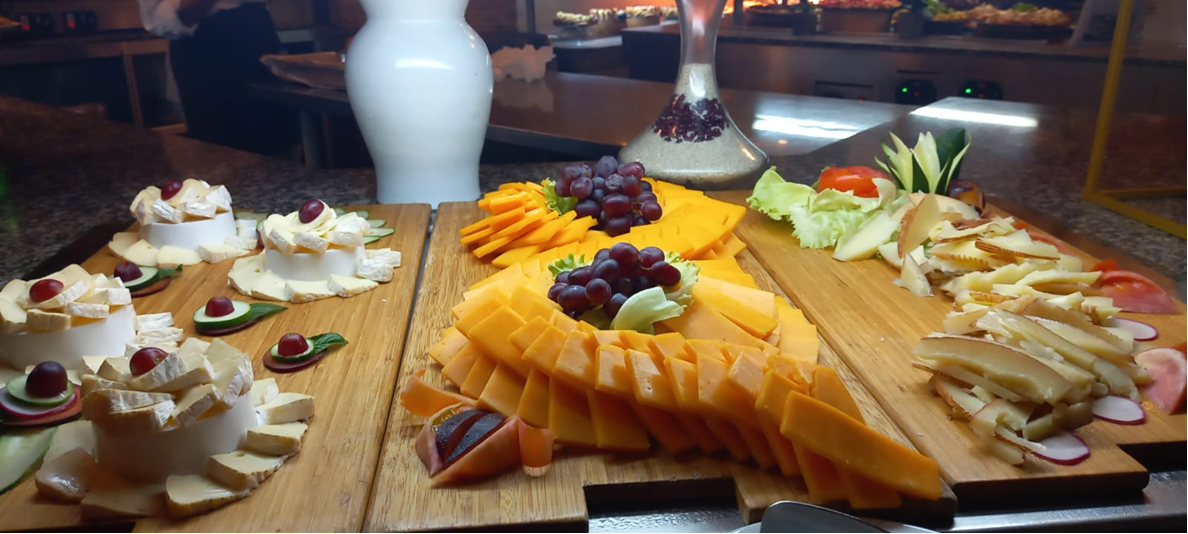 Cheese platters and fruit boards arranged on wooden service trays.
